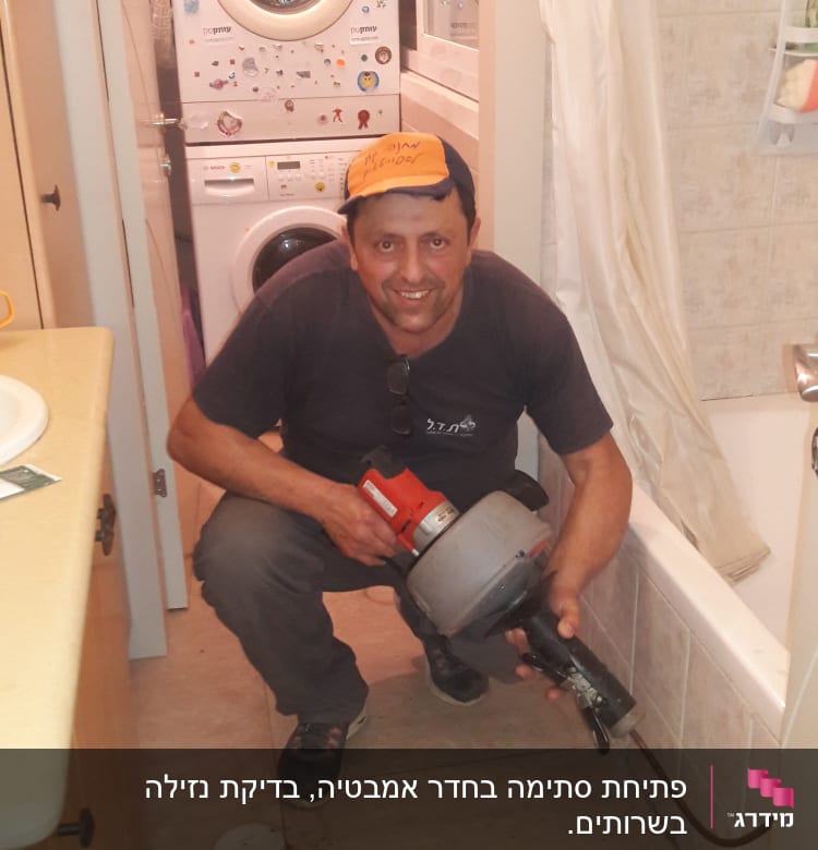 אדם מחזיק כלי עבודה ליד אמבטיה